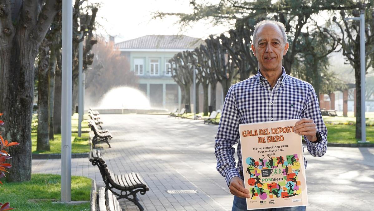 El concejal Chus Abad, con el cartel de la Gala del Deporte, en el parque Alfonso X de Pola de Siero.