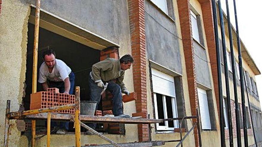 Dos albañiles trabajan en el albergue municipal de Santibáñez de Vidriales.