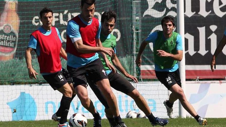 Andrés Túñez protege el balón ante Oubiña en presencia de Bellvís y Toni durante el entrenamiento de ayer en A Madroa. // Ricardo Grobas