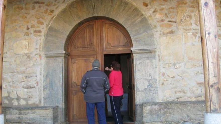 Una vecina señala una gran mancha de humedad en la pared de la iglesia.