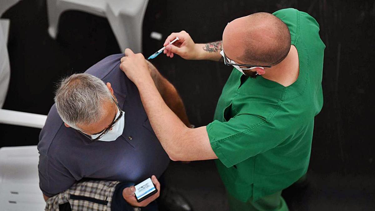 Un hombre recibe una dosis de la vacuna frente al COVID, ayer, en Expocoruña. |   // VÍCTOR ECHAVE