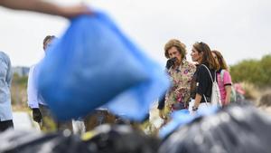 Doña Sofía, recogiendo basura marina en la orilla del mar, esta mañana en la playa de la Caleta del Estacio.