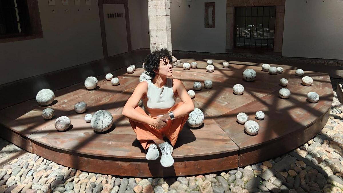 Tania Blanco con las esferas cerámicas de "Fierro", en la Casa de Cultura de Grado.