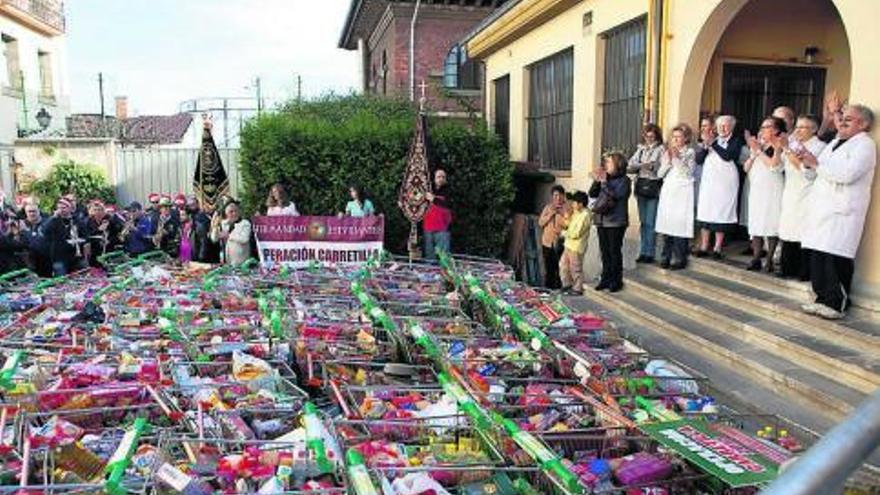 A la derecha, monjas y voluntarios de la Cocina Económica, aplaudiendo a la llegada de los carritos.