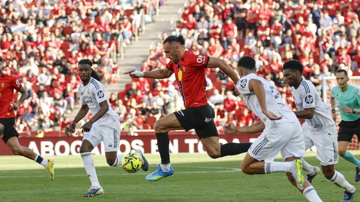 El delantero kosovar del Mallorca Vedat Muriqi (c) ante la defensa del Real Madrid durante el partido de la jornada 30 de LaLiga EA Sports, que disputan el RCD Mallorca y el Real Madrid este sábado, en Son Moix, Palma de Mallorca. EFE/ Cati Cladera. (Mallorca)