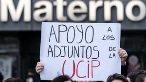 Un hombre sujeta una pancarta durante una manifestación tras el cierre de la UCI pediátrica del Hospital Universitario La Paz