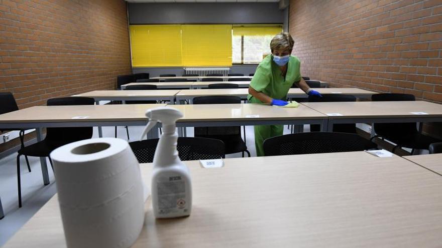 Una trabajadora desinfecta una mesa en el campus de Pontevedra.