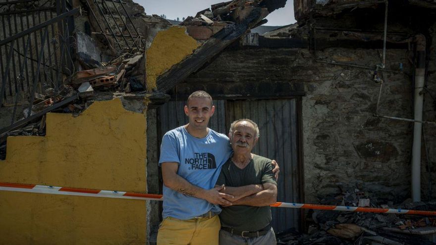 Brian y su padre, ante la casa que arrasó el fuego en O Castelo (Rubiá).