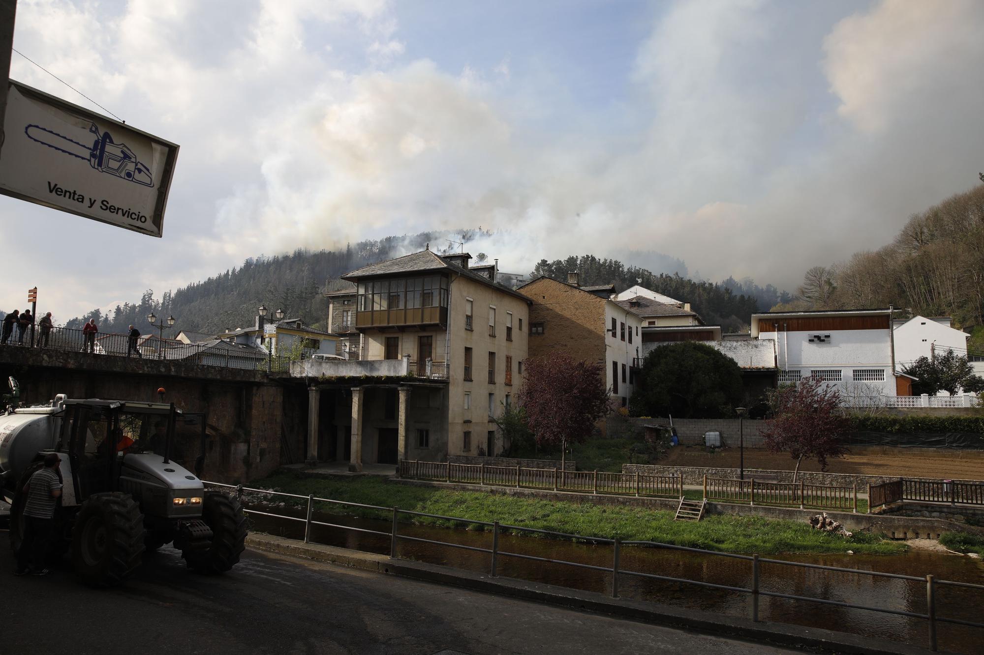 Agricultores ayudando en la extinción de los focos de fuego y enfriando las inmediaciones de la gasolinera de Navelgas