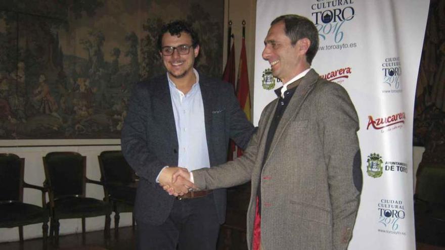 Tomás del Bien (izquierda) y Juan Luis Rivero estrechan sus manos para sellar el acuerdo firmado ayer en el Ayuntamiento. Foto