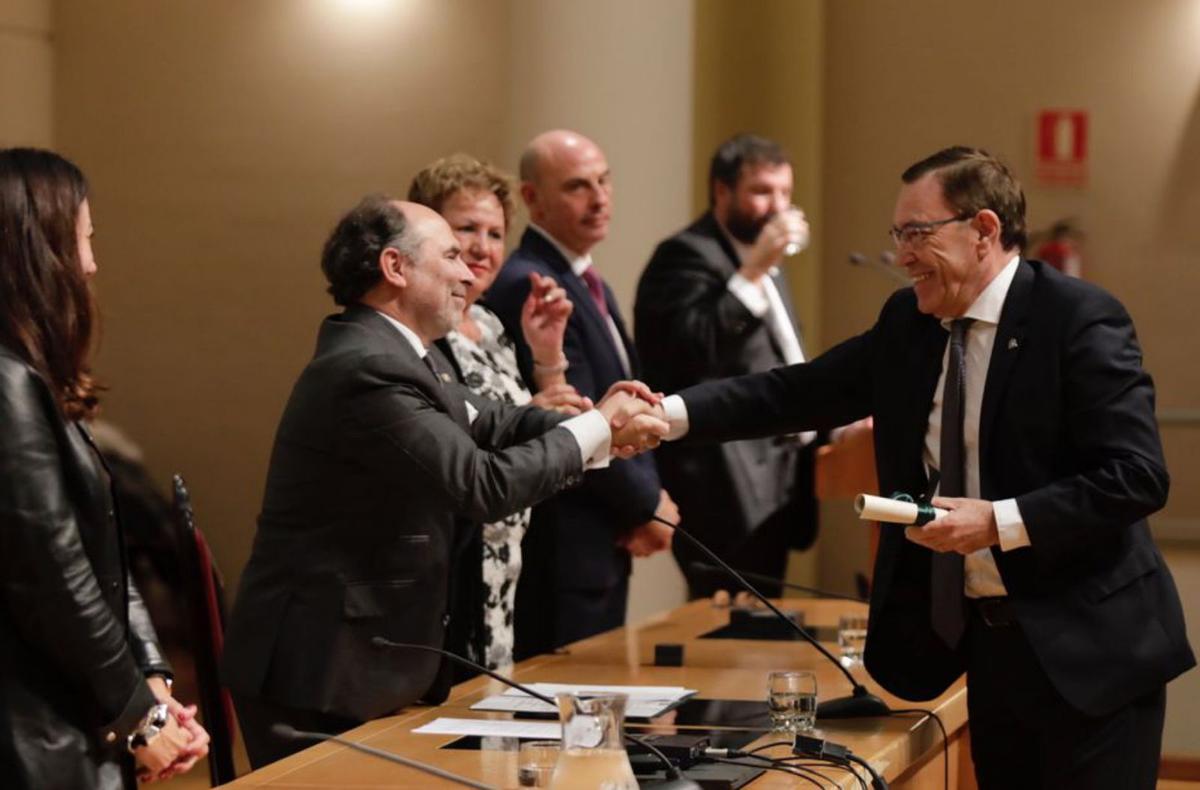 El rector Villaverde estrecha la mano al exrector Juan Vázquez en el momento de la entrega de la insignia de oro. | Fernando Rodríguez