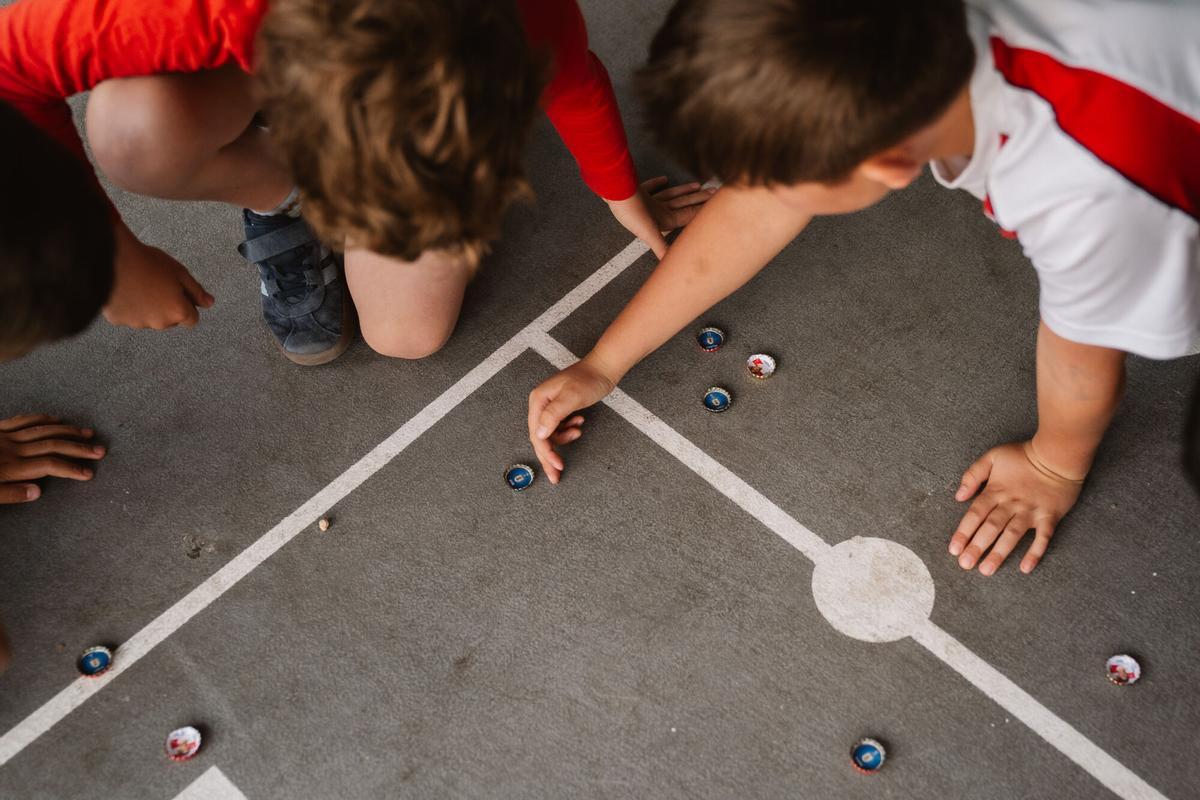 Niños juegan al fútbol chapa en el Colegio Claret de Madrid.