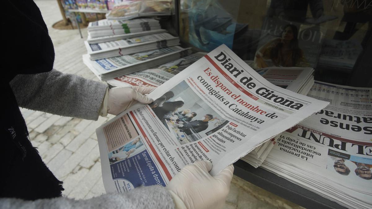 Una lectora escollint el diari de Girona en un quisoc