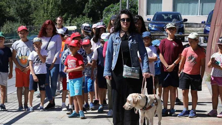 Lucía González, con su perra Lucy y los niños del Aula de la naturaleza de Oira, ayer. // Jesús Regal