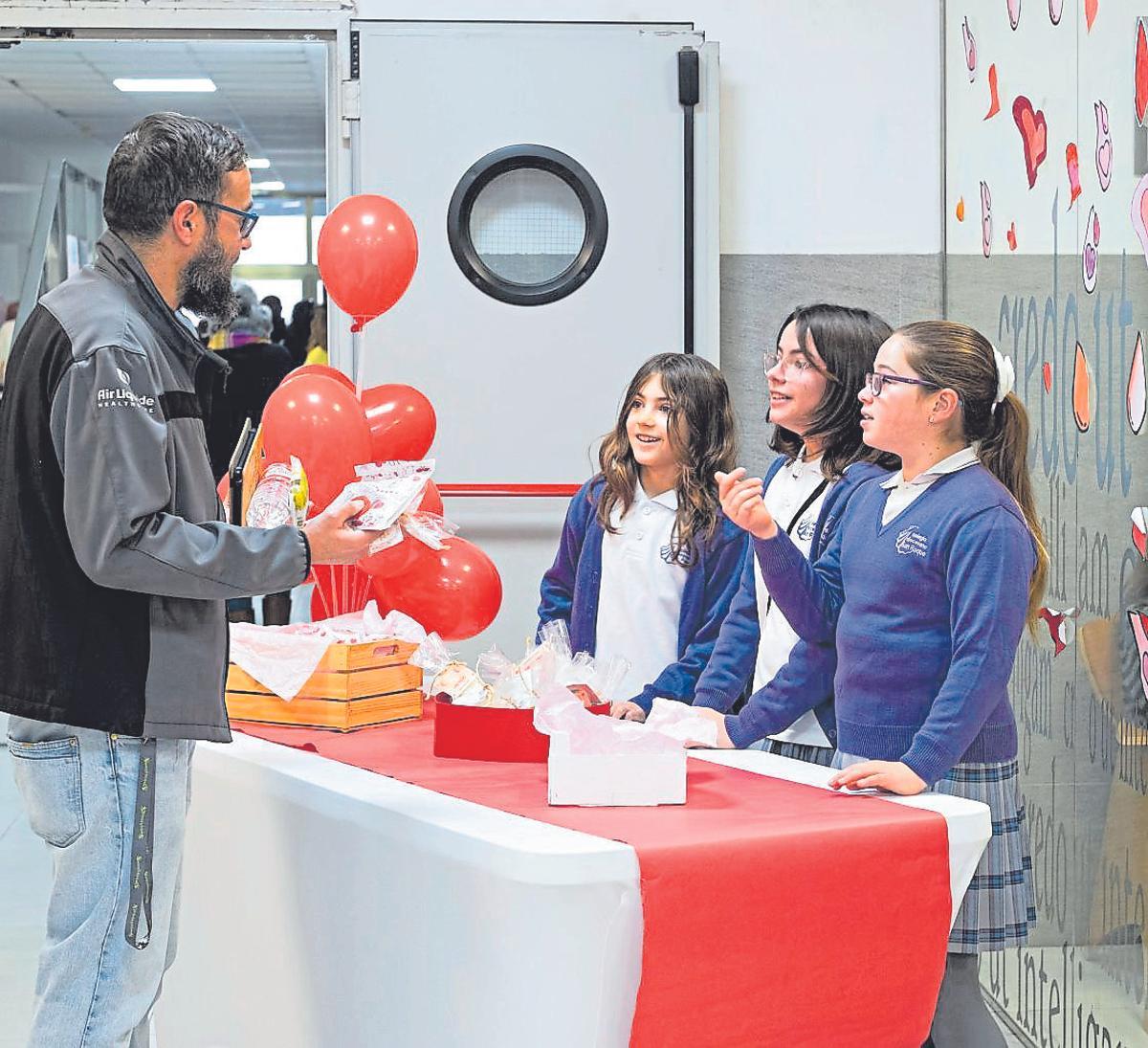 Xiquetes del Col·legi San Roque de Benicalap entregant a un donant de sang els detalls que han elaborat per agrair-li el seu gest.
