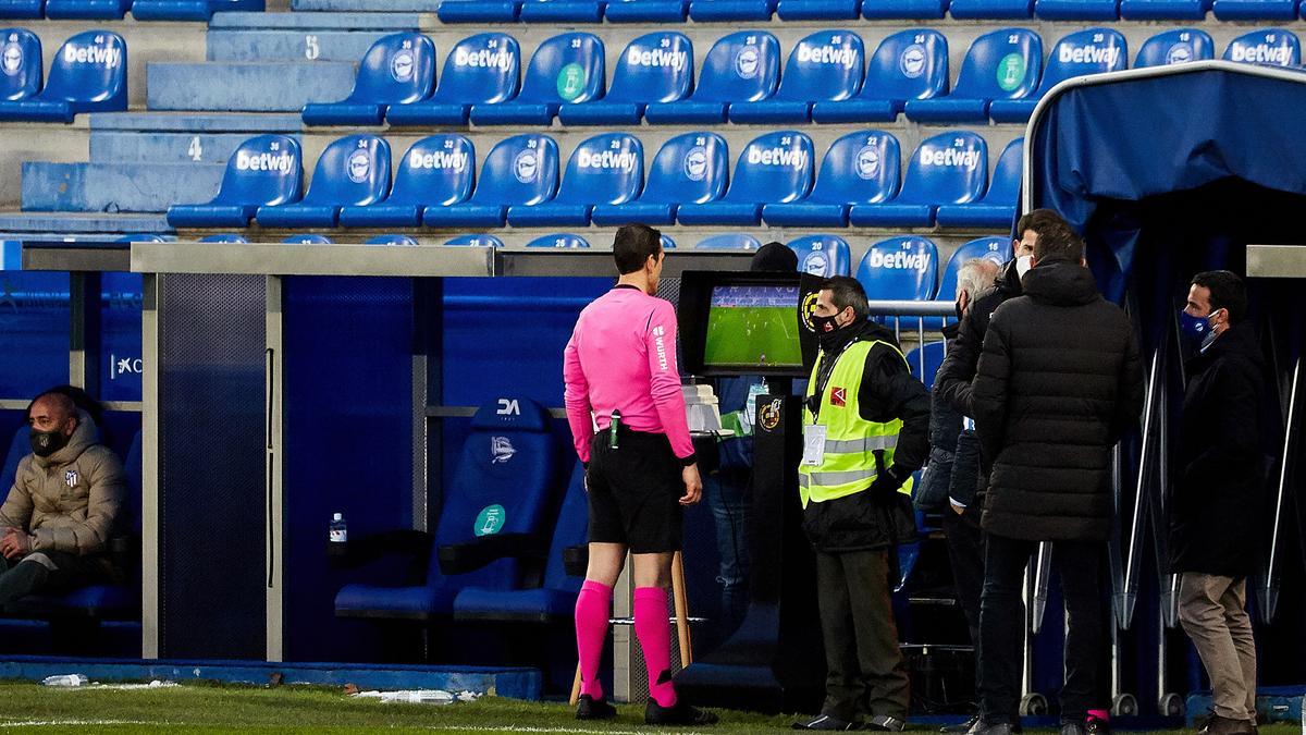 Un árbitro revisando una acción en el monitor del VAR.