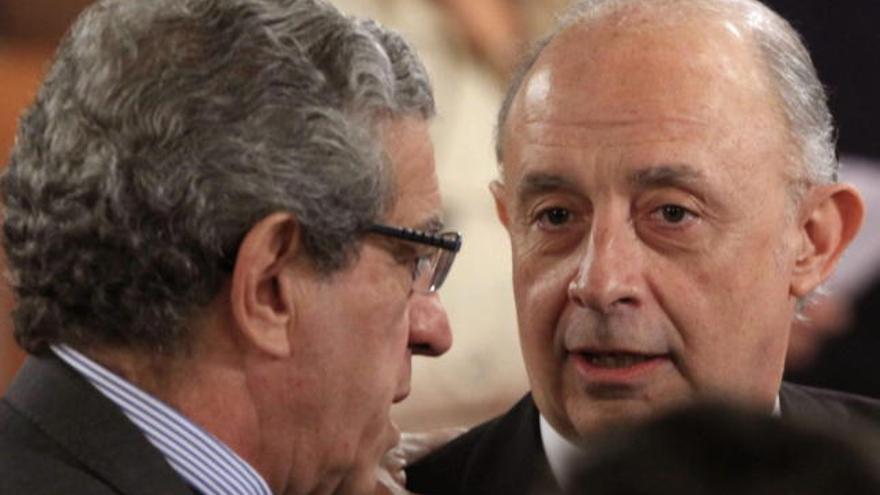 El ministro de Hacienda, Cristobal Montoro (d), y el presidente de Unicaja, Braulio Medel, charlan antes de la toma de posesión de José Antonio Griñán