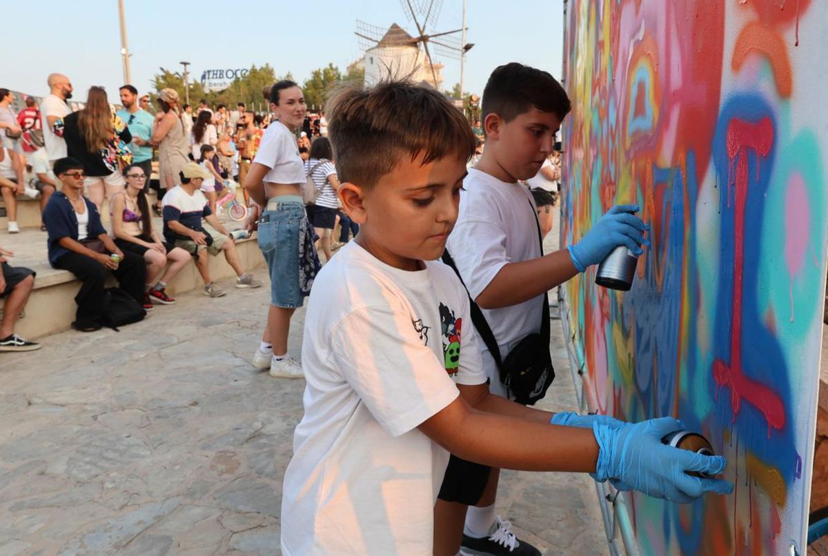 Dos niños ponen a prueba su destreza con el espray. |  | J.A. RIERA