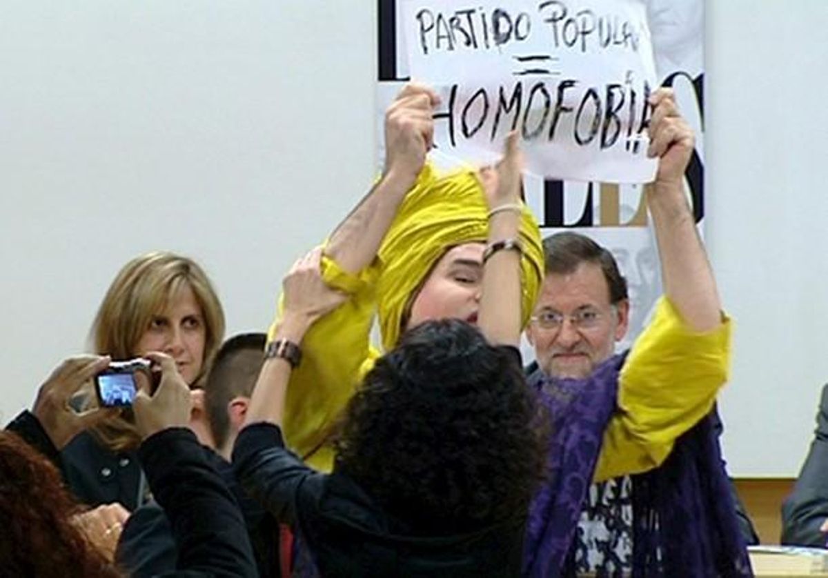 La ’drag queen’ Shangay Lilly mostra una pancarta en què qualifica d’homòfob el PP davant la presència de Mariano Rajoy, avui a Madrid. La ’drag queen’ Shangay Lilly mostra una pancarta en què qualifica d’homòfob el PP davant la presència de Mariano Rajoy, avui a Madrid.