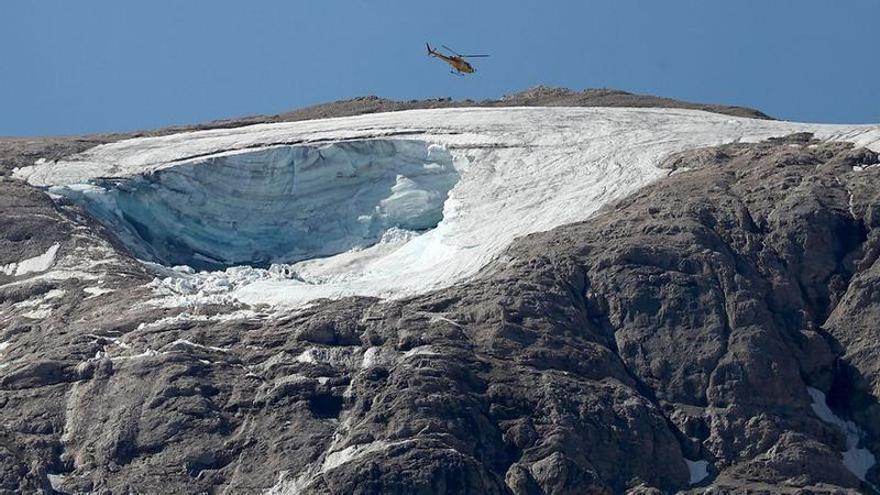 Un helicópteru sobrevuela la parte del glaciar que se desprendió nel monte Marmolada, n&#039;Italia.