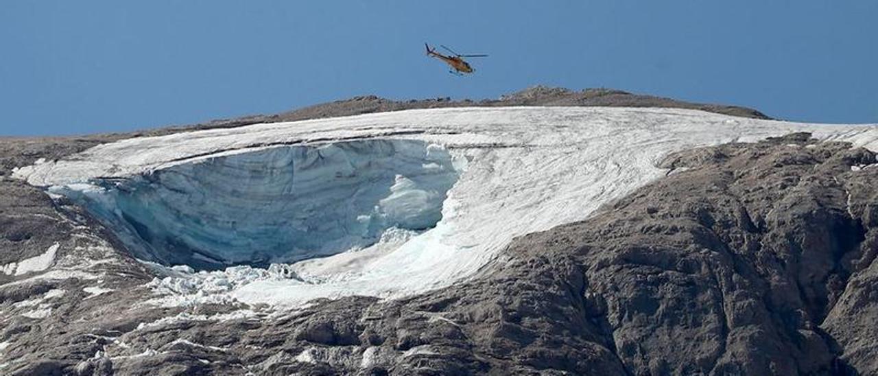 Un helicóptero sobrevuela la parte del glaciar que se ha desprendido en la montaña Marmolada, en Italia.