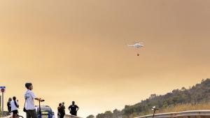 En la Vall dUixò varias persona observan el cielo y las labores de emergencia