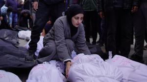 Una mujer junto a los cuerpos de varias personas muertas en el bombardeo del hospital Mártires de Al Aqsa, en Deir al-Balah, en el centro de la Franja de Gaza.