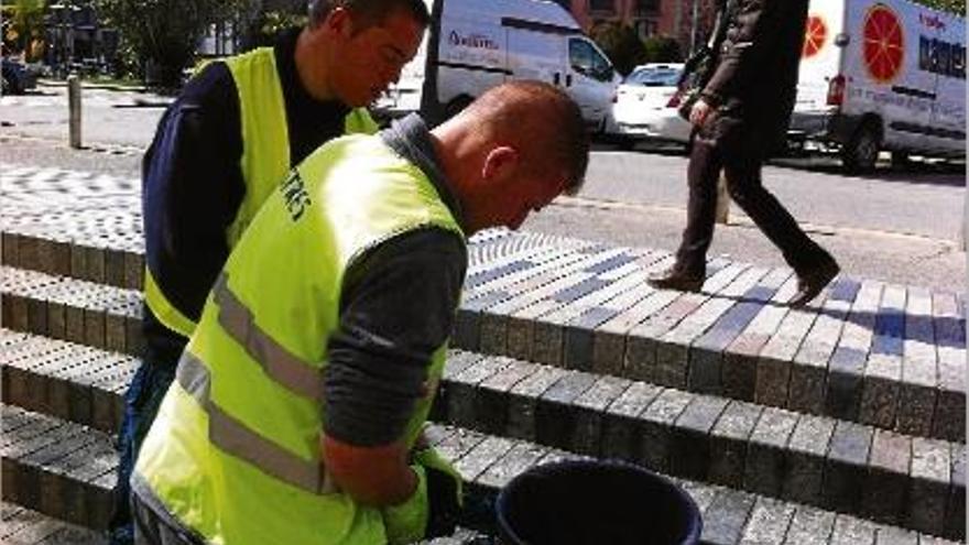 Dos treballadors de la Fundació Astres instal·lant un dels rascadors a tocar de la plaça Catalunya.