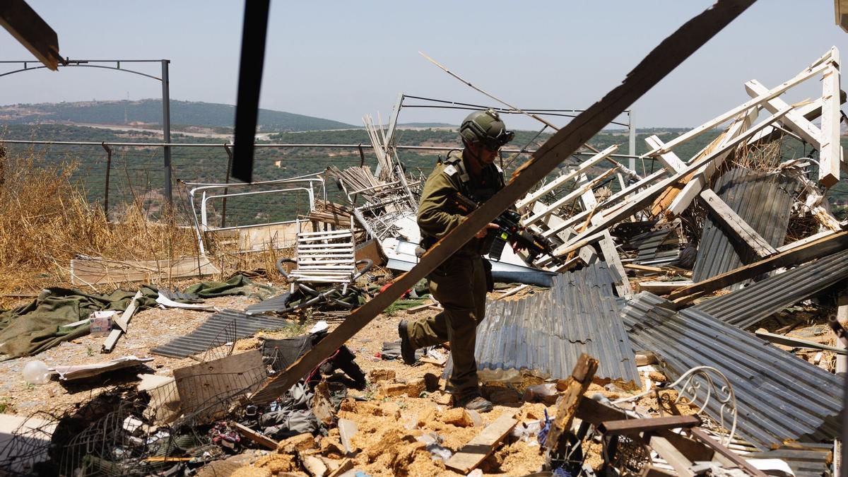 Un soldado israelí examina los restos de un bombardeo de Hizbulá en la localidad de Moshav Shtula, en el norte de Israel.