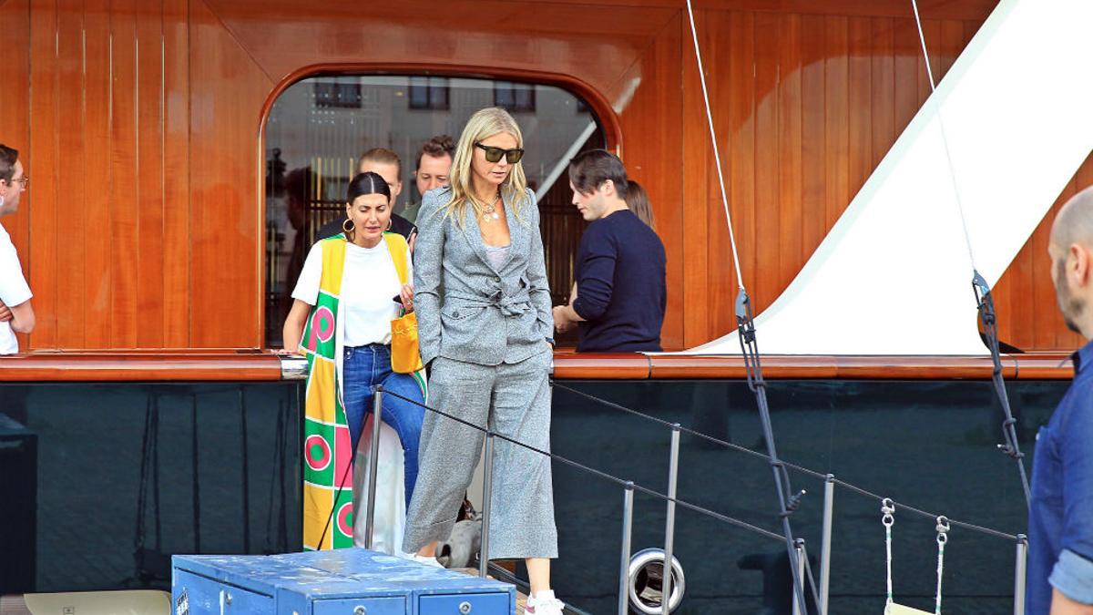 Gwyneth Paltrow saliendo del barco de la diseñadora Diane Von Fürstenberg con un traje de chaqueta gris atado a la cintura y de corte pirata