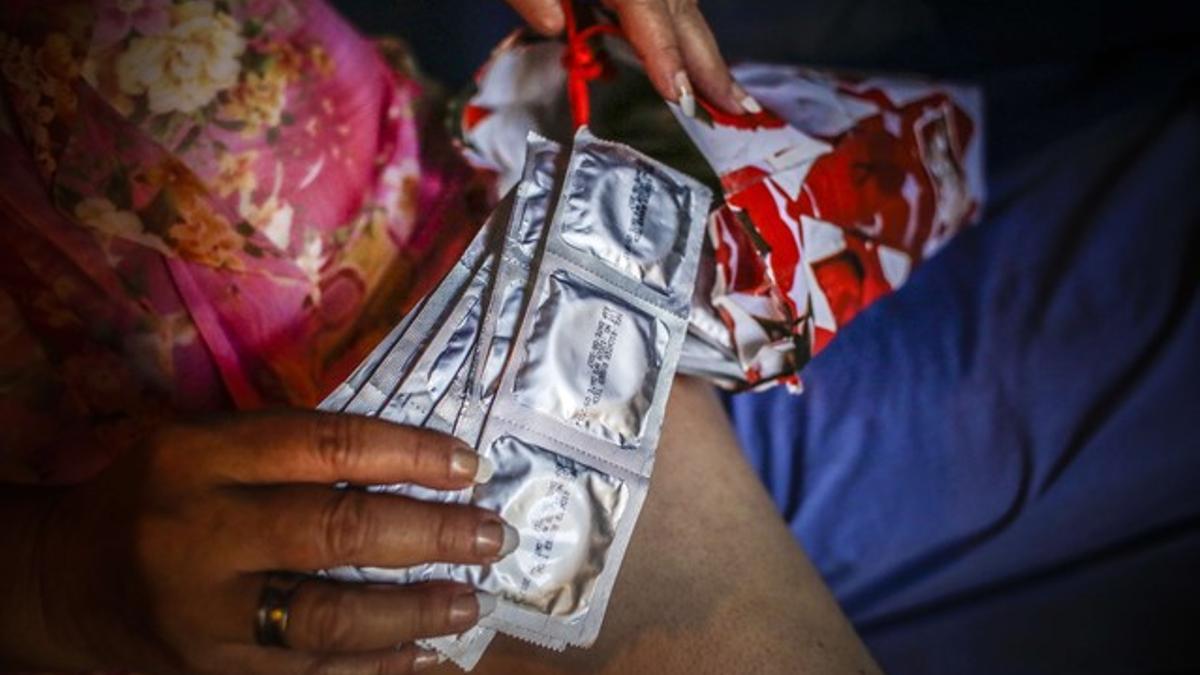 La prostituta Concepción de María Jarquín, de 46 años, muestra un paquete de condones.