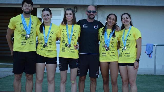 El Atletismo A Estrada posa con las medallas conseguidas en el Gallego junto a su técnico Marcos Otero. |