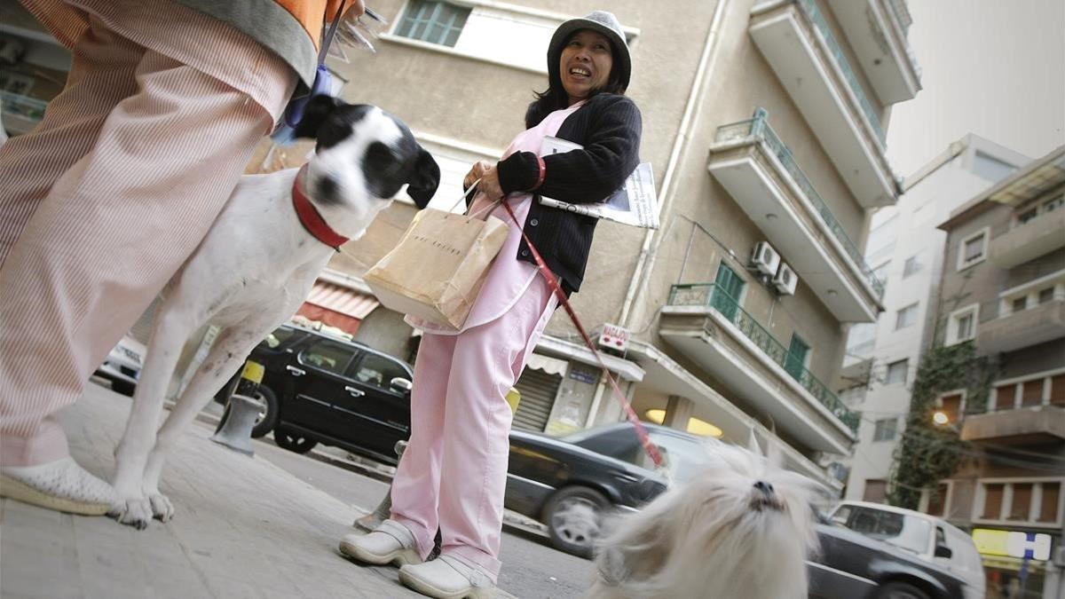 Una empleada doméstica filipina pasea un perro en Beirut.