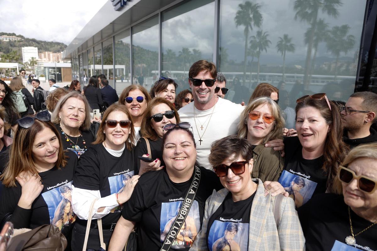 William Lev posando sonriente con sus uniformadas fans