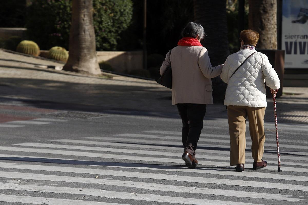 Personas mayores pasean por la calle en Málaga.