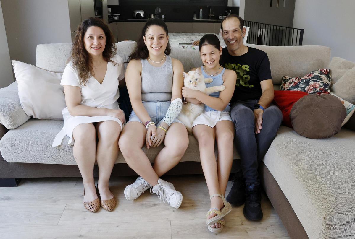 Sonia Río y Manuel González, padres de Aitana, que nació sin mano izquierda, y Alegra, en su casa en Cans, y el gato de la familia, Bluí