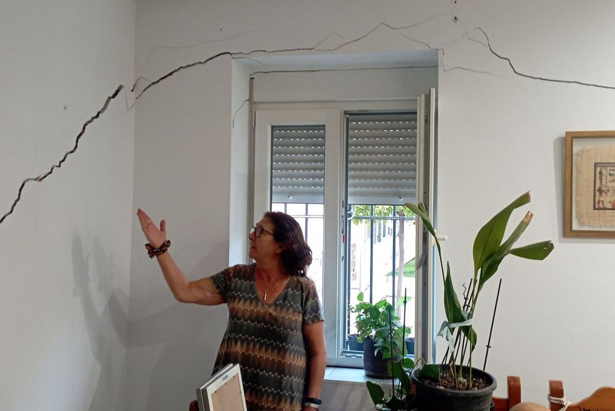 1. Carmen Yélamos muestra la enorme grieta de su salón, esta semana.
2. Detalle de una de las grietas de un bloque.
3. Dirigentes vecinales de Haza de Cuevas y Carranque, junto a una fachada dañada.
4. Detalle de los daños en otro bloque de Haza de Cuevas. | A.V.