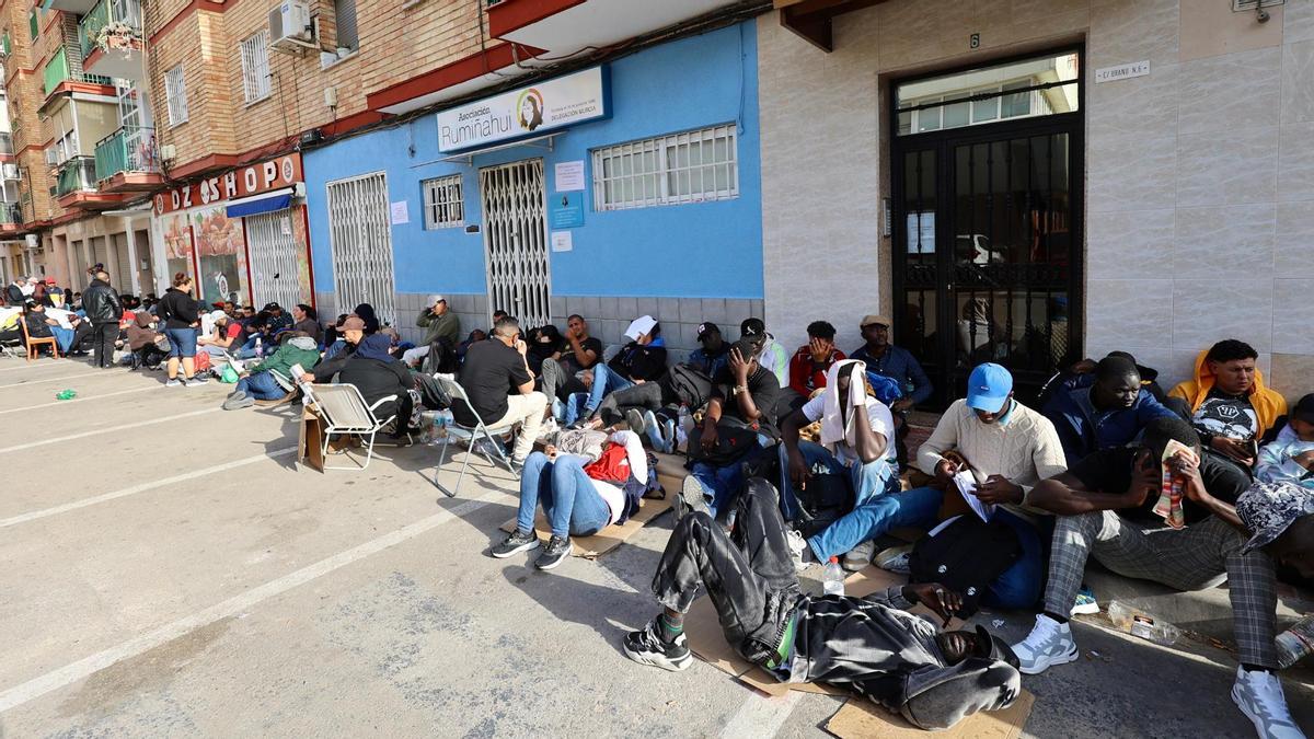 Gente acampando a las puertas de la asociación Ruminahui, en la calle Urano de San Pío X, este martes por la tarde.