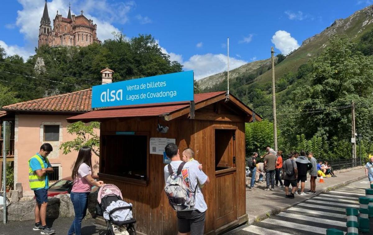 Varios visitantes aguardan la llegada de un autobús en Covadonga.