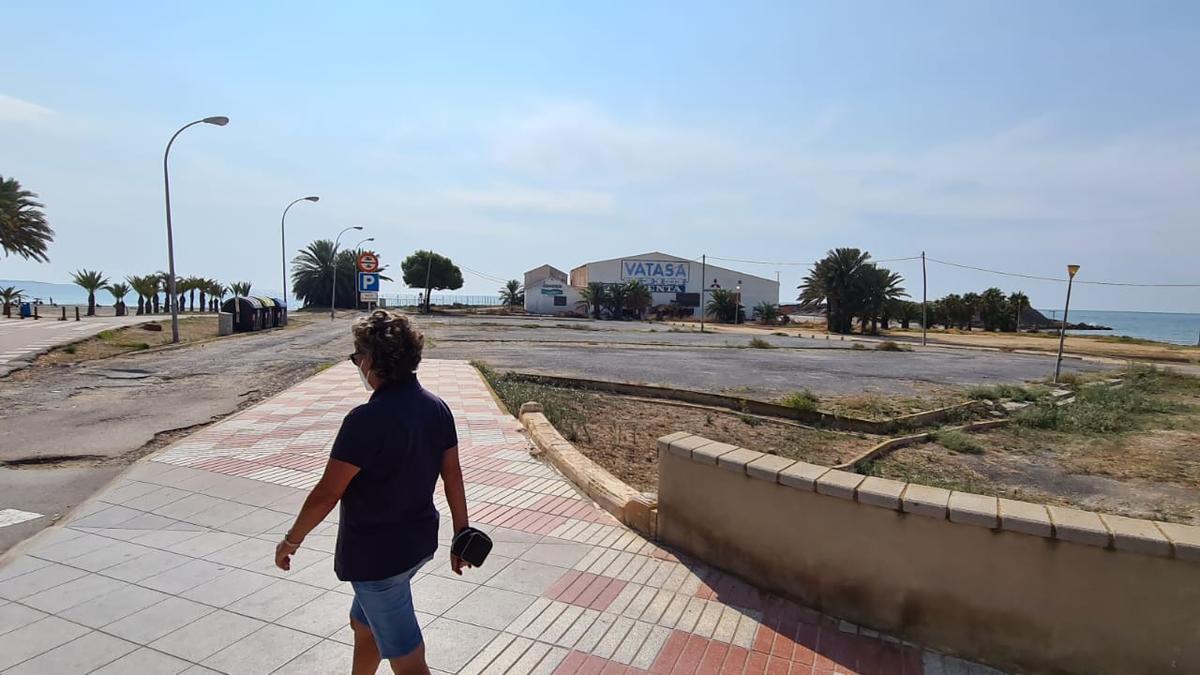 Un vecino en el paseo con las naves de Vatasa al fondo.