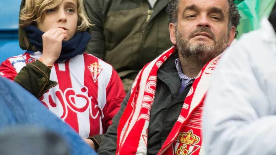 Un padre y su hijo siguen el partido con atención.