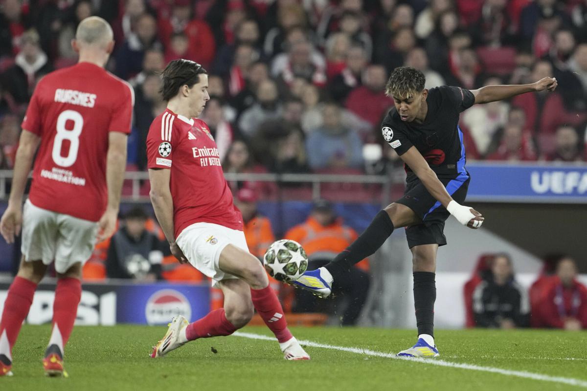 Barcelona's Lamine Yamal, right, attempts a shot at goal in front of Benfica's Alvaro Carreras, center, during the Champions League round of 16 first leg soccer match between SL Benfica and FC Barcelona at the Luz stadium in Lisbon, Wednesday, March 5, 2025. (AP Photo/Armando Franca). EDITORIAL USE ONLY / ONLY ITALY AND SPAIN