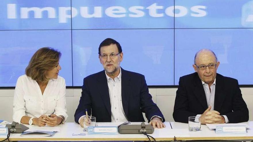 María Dolores de Cospedal, Mariano Rajoy y Cristóbal Montoro, ayer, en la sede del PP en Génova.