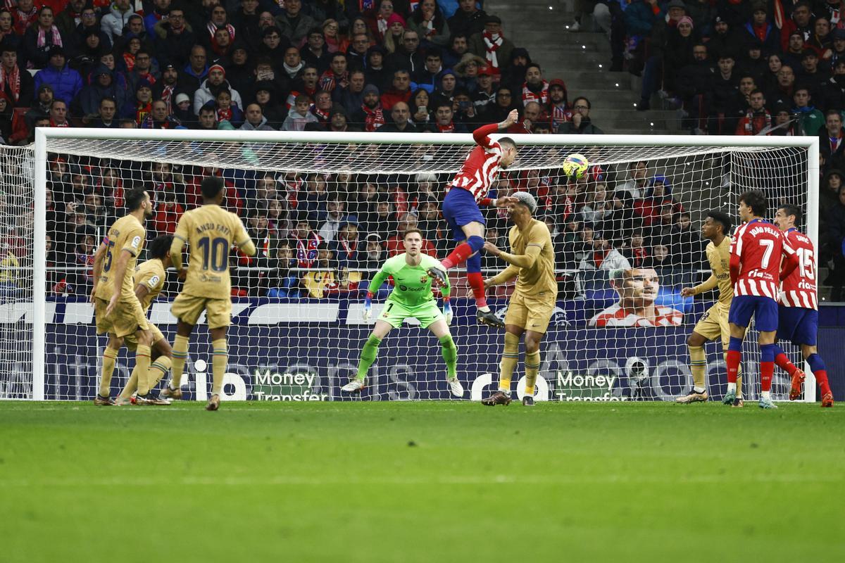 El defensa uruguayo del Atlético de Madrid, José María Giménez (5i), remata ante el defensa uruguayo del FC Barcelona, Ronald Araujo, durante el encuentro correspondiente a la jornada 16 a en el estadio Metropolitano, en Madrid. EFE / Rodrigo Jiménez.