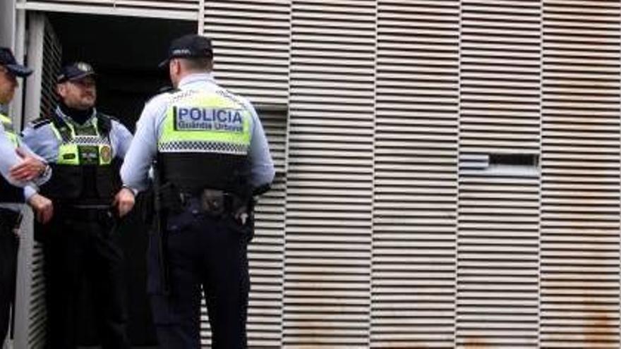 Agents de la Guàrdia Urbana controlant l&#039;accés a un dels blocs ocupats de la plaça Joan Tutau.