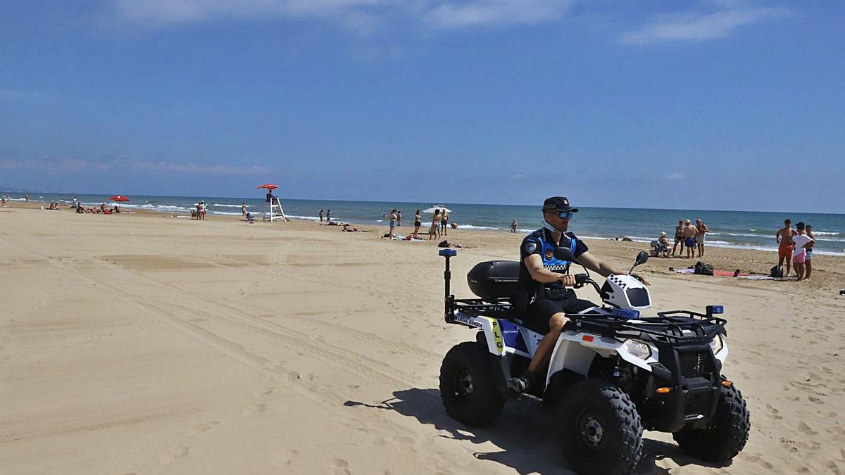Un agent de la Policia Local de Gandia amb un ‘quad’ patrullant per l’arena de la platja Nord. | ÀLEX OLTRA