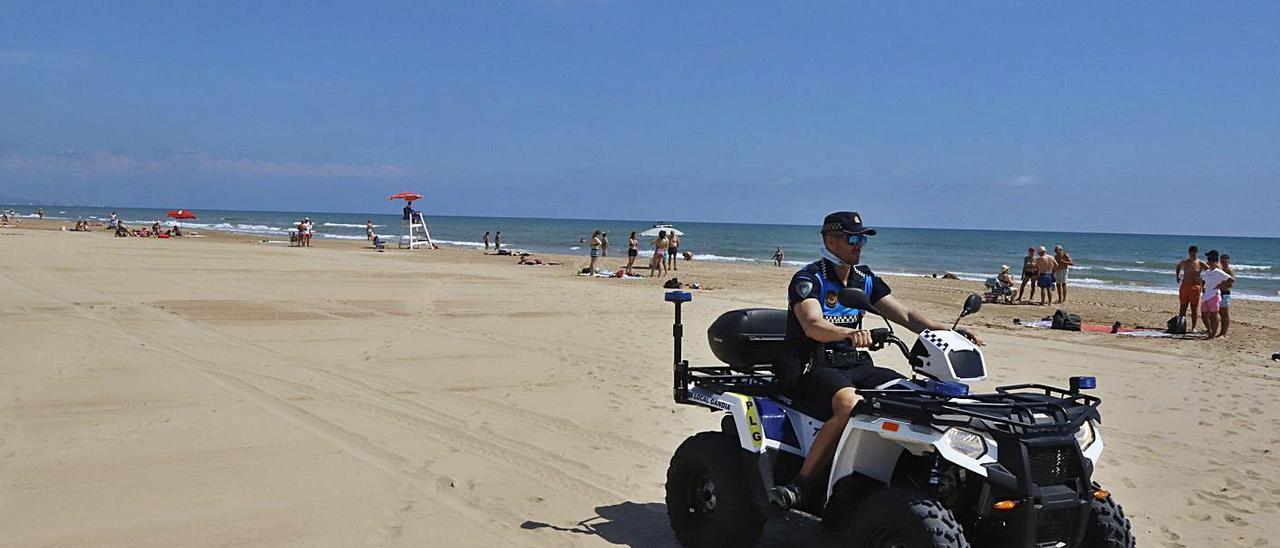 Un agente de la Policía Local de Gandia con un quad patrullando por la arena de la playa Nord.                    | ÀLEX OLTRA