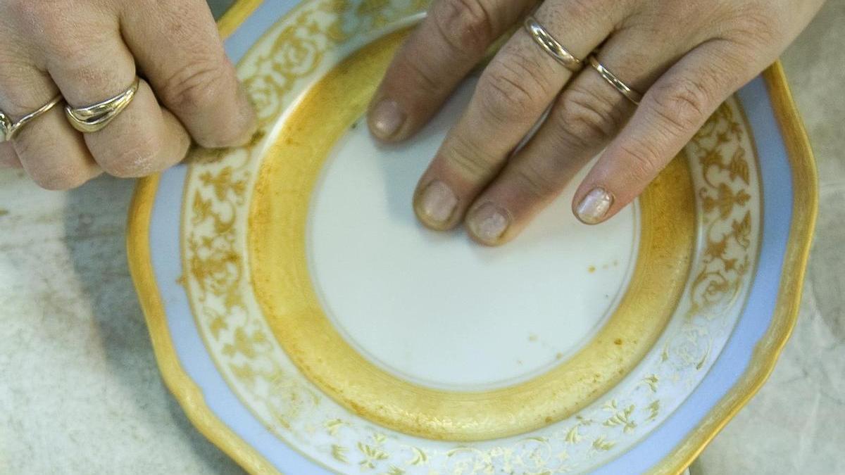 Una artesana decora porcelana de Limoges.