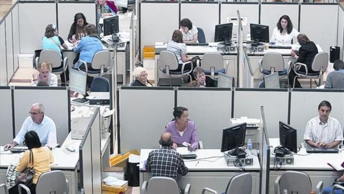 Oficina de l’Agència 8 Diversos treballadors atenen contribuents a la seu de Madrid. Oficina de l’Agència 8 Diversos treballadors atenen contribuents a la seu de Madrid.