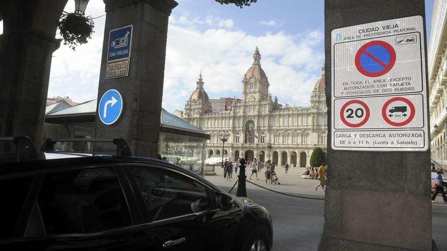 Un vehículo entra a la Ciudad Vieja por María Pita, ante los carteles que prohíben aparcar en el barrio.